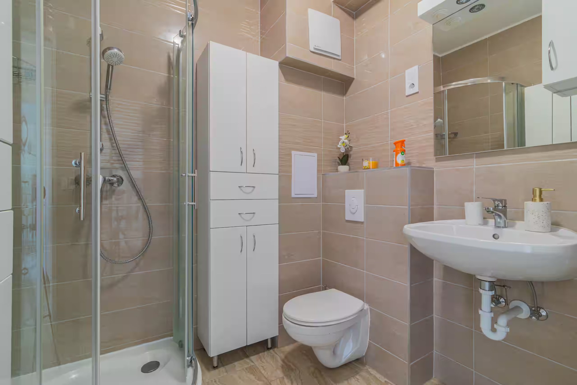 Badezimmer mit Duschkabine, Waschbecken und WC