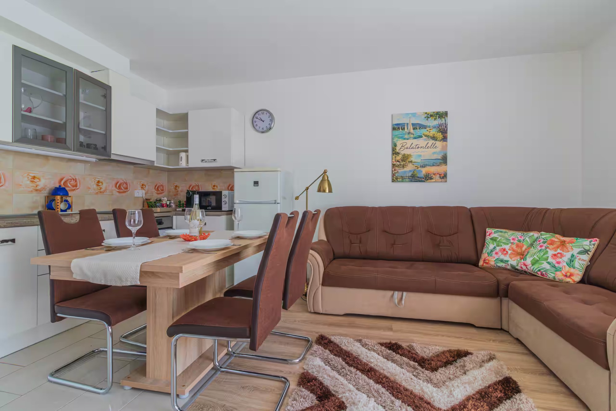 Wohnzimmer mit Sofa, Esstisch für vier Personen und Küche